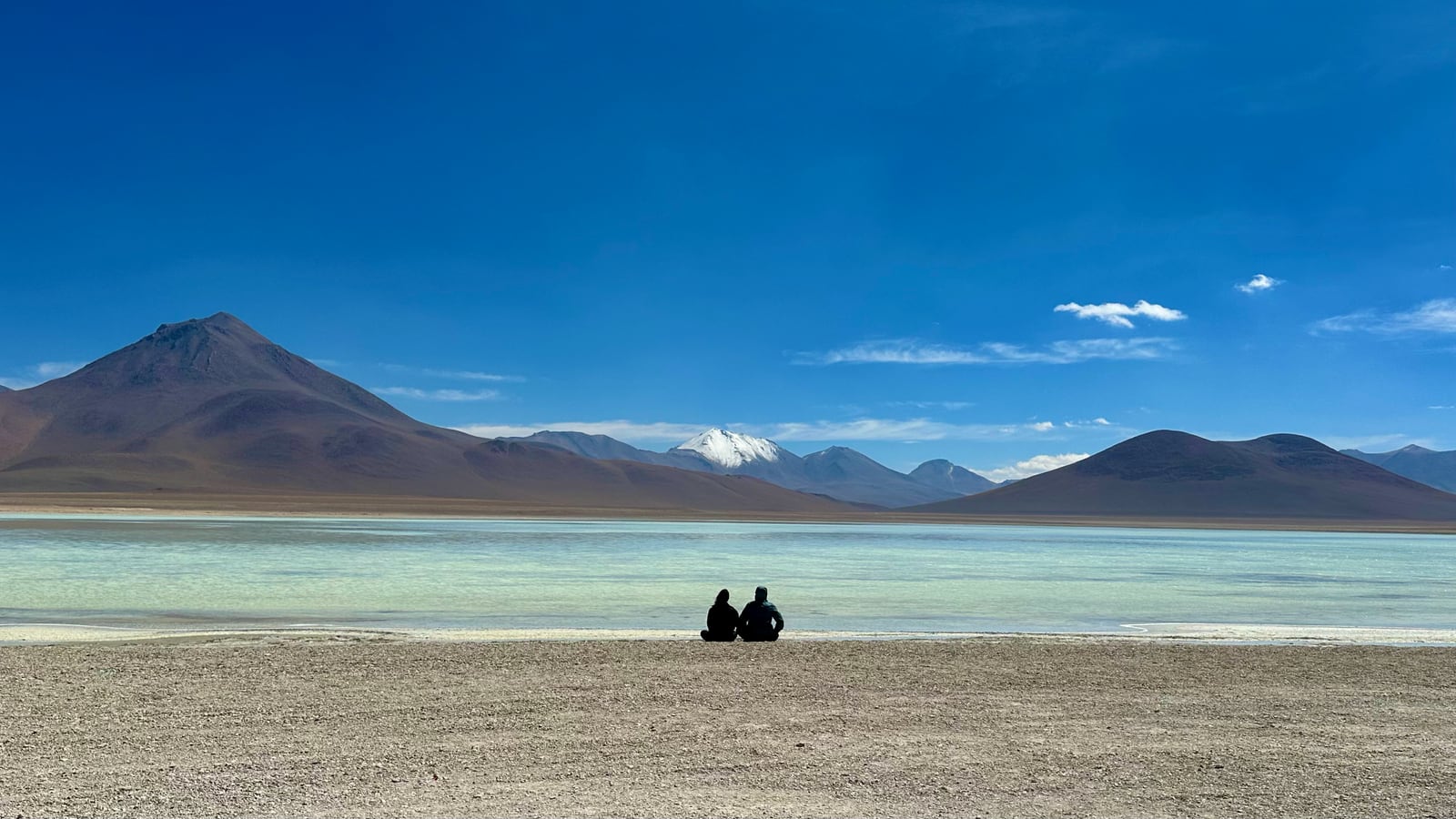 Laguna altiplânica com vulcões ao fundo, no deserto do Atacama