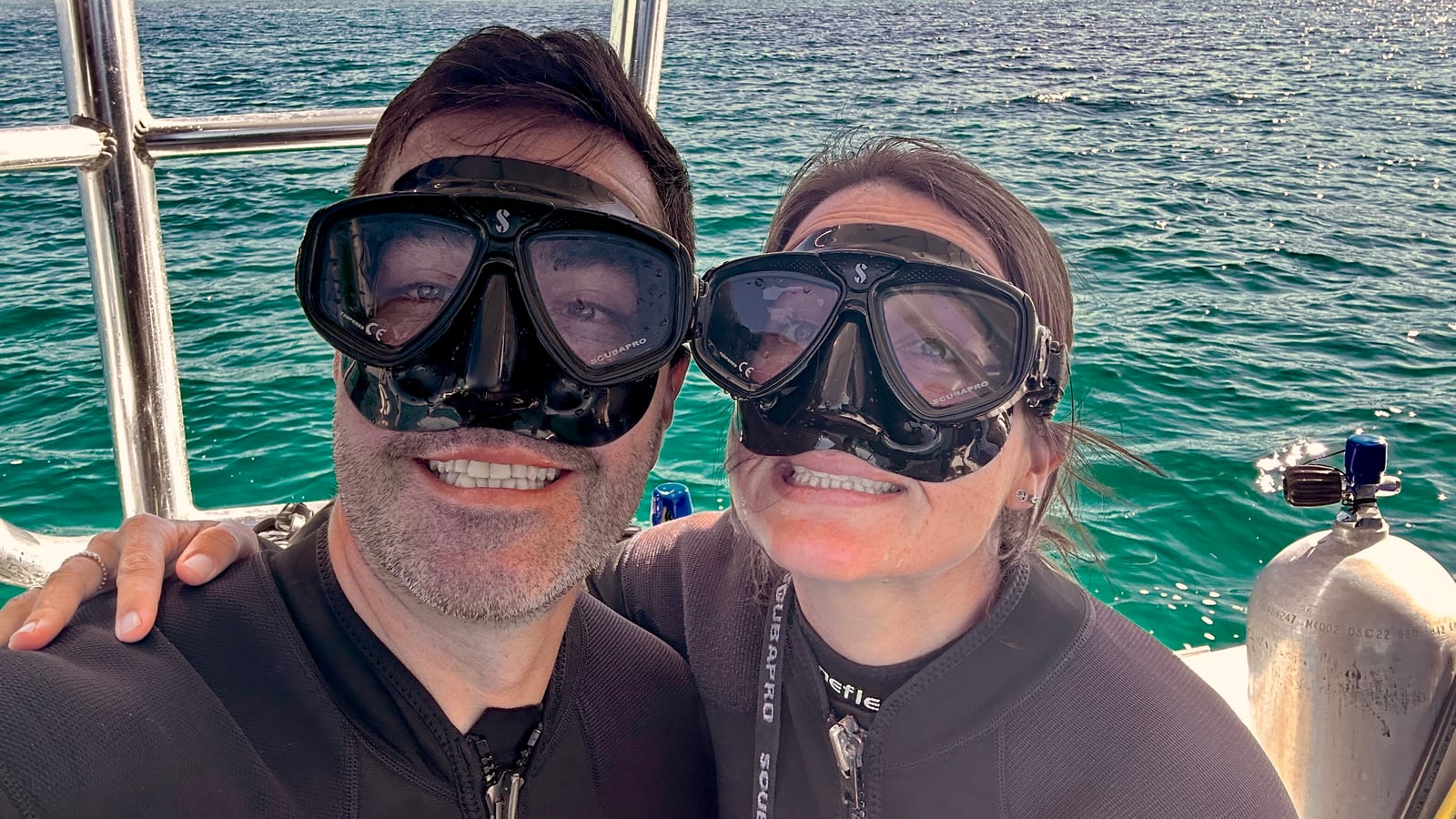 Thaíssa e Julián de máscara de mergulho, dentro do barco, antes de cair na água